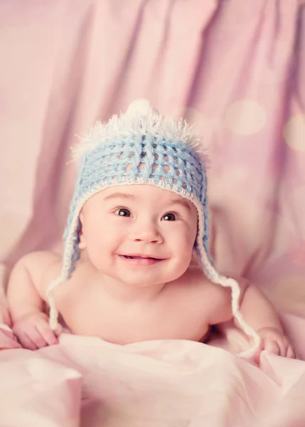 Smuk glad og smilende baby ligger på en mave - Stock-foto