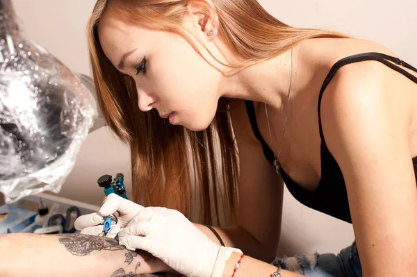 Vacker ung flicka tatuering artist porträtt under skapelsen tatuering — Stockfoto