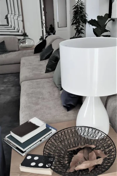 Bej kanepeli, yeşil yastıklı ve puflu modern bir salon.