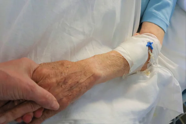 Een close-up. Mannelijke hand met een druppelaar in een ziekenhuis. — Stockfoto