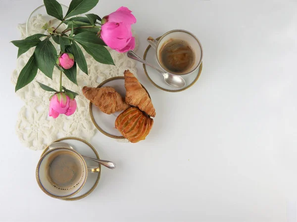 Завтрак с двумя чашками кофе и круассанами, букет розовый — стоковое фото