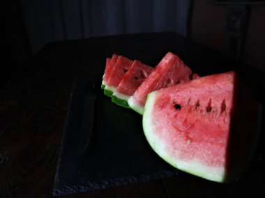 Siyah üzerine dilimlenmiş kırmızı karpuz. 