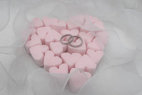 Conceito de casamento. Corações de marshmallow, dois anéis em um ba branco — Fotografia de Stock