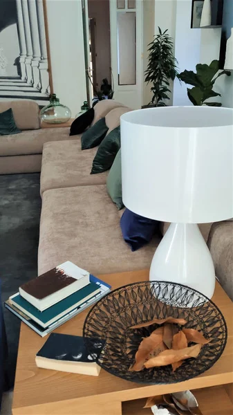 Bej kanepeli, yeşil yastıklı ve puflu modern bir salon.