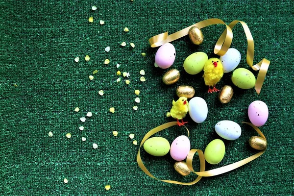 Huevos de Pascua dorados y gallinas sobre un fondo verde —  Fotos de Stock