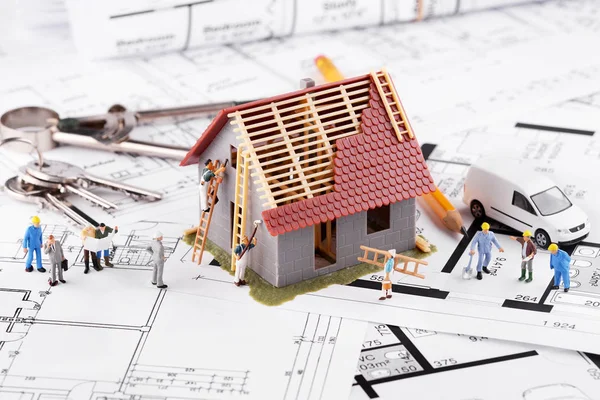 Tiny people build houses for architectural plans. The concept of — Stock Photo, Image