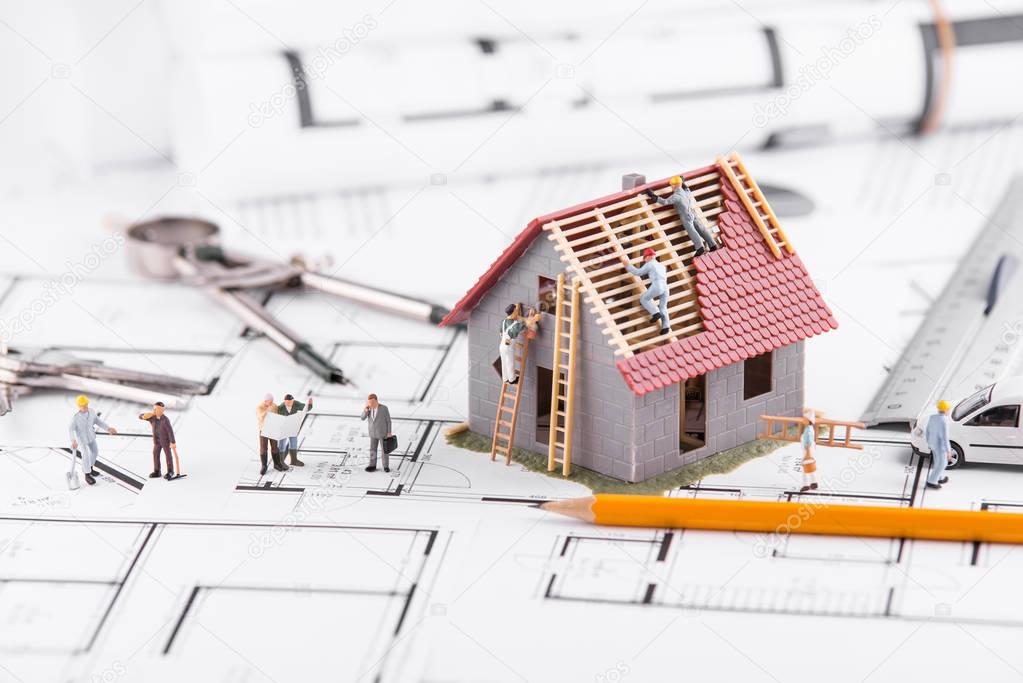 Tiny people build houses for architectural plans. The concept of