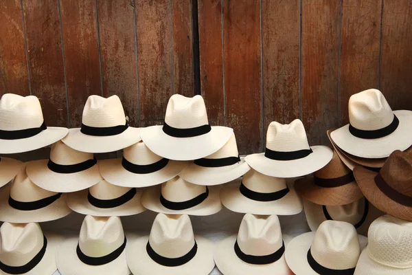 A selection of Panama hats piled up against a wooden door, Cartagena, Colombia. — Stock Photo, Image