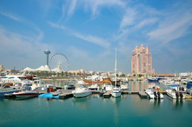 Abu Dabi Marina 'nın arka planında şehrin sembolik simgeleri var. Birleşik Arap Emirlikleri..