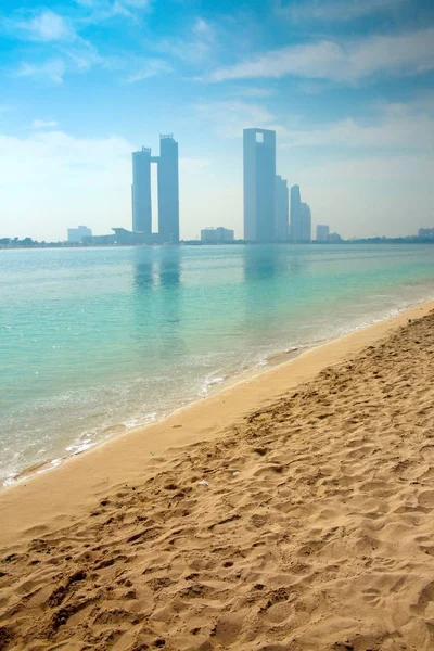 Skyline Abu Dhabi avec des gratte-ciel dans le bachground à travers l'océan & une belle plage au premier plan, Émirats arabes unis . — Photo