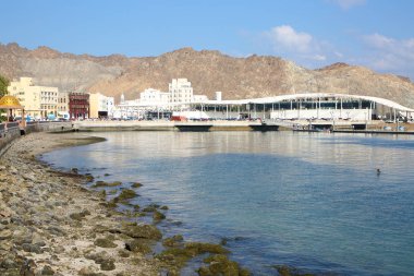 Muscat şehrinin rıhtımı, Umman, önü ve arkası dağlarla çevrili binalar..