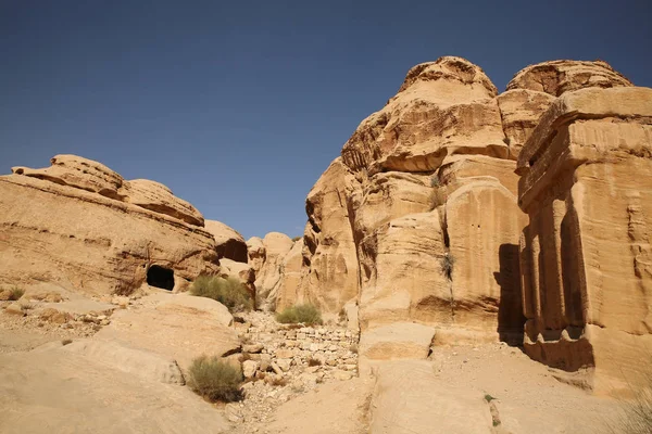 Grotwoningen of huizen langs het pad naar de Siq, dat is de smalle kloof passage die u loopt langs naar Petra bereiken, Jordanië. — Stockfoto