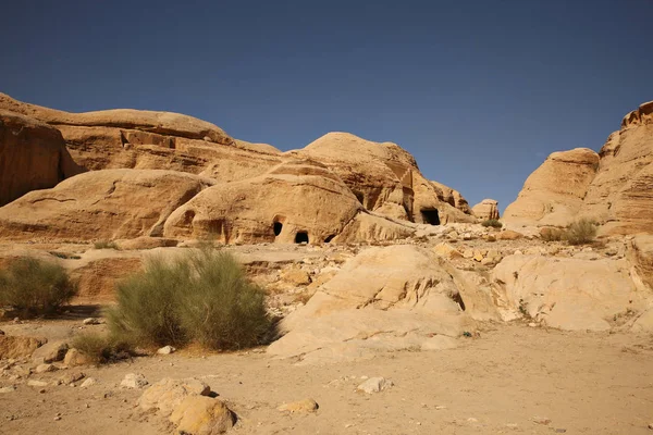 Siq yolu boyunca uzanan mağara evleri veya evler, Ürdün Petra 'ya ulaşmak için yürüdüğünüz dar bir geçittir.. — Stok fotoğraf