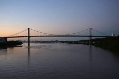 Gün batımında Pont d 'Aquitaine Köprüsü' nde. Fransa 'nın Bordeaux şehrinin kuzeybatısında, Garonne üzerinde büyük bir asma köprüdür..
