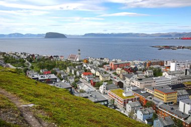 Town of Hammerfest with the downtown area, and cathedral with mountains & fjords in the background. Hammerfest is the northernmost town in the world with more than 10,000 inhabitants, county, Norway. clipart