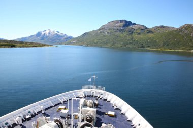 Bir geminin fiyortlarda, adalarda ve geçitlerde gezinirken güverte & rayları; Bodo & Çekiç Festivali, Norveç arasında Andfjorden & Vestfjorden. 