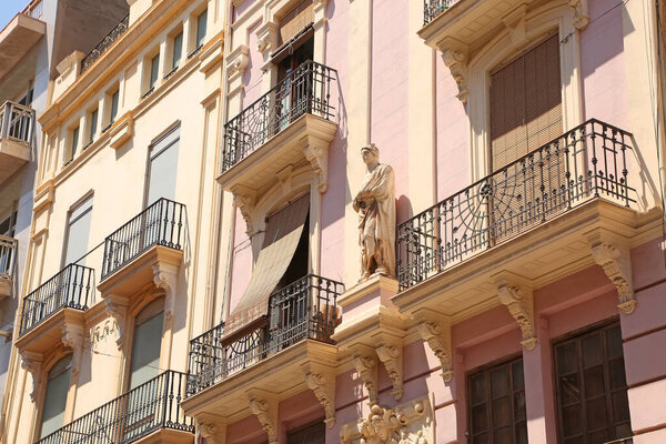 Close up of beautiful historic buildings & statue on one of the streets in the downtown city center, in the city of Castellon, Valencia, Spain.
