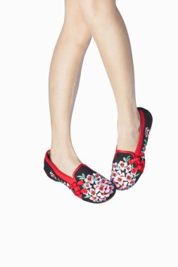 İşlemeli ayakkabılar ayağından giymiş