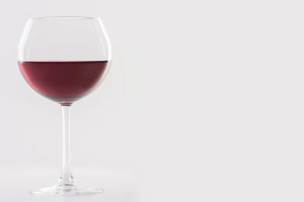 白い背景と柔らかい影の上に赤ワインのガラス。テキストの場所があります。. — ストック写真