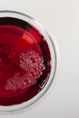 Gölgeli bir kadeh kırmızı şarap. Süper manzara. Soyut kırmızı şarap kabarcıkları.