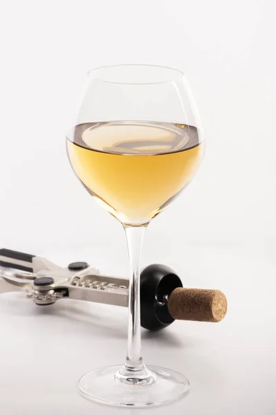 High angle view with shallow depth of field of a glass of white wine with a corkscrew. — Stock Photo, Image