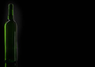 Şarap yeşil şişe silueti. Siyah arkaplanın önünde mantarlı bir şarap şişesinin açılışı..