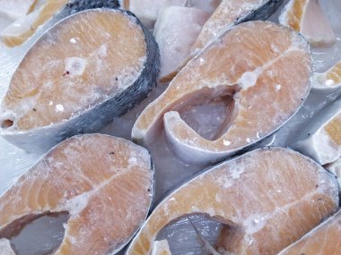 Taze somon, fileto ve bütün olarak süpermarkette buzda sergileniyor. Yakın plan.