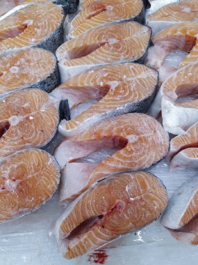 Taze somon, fileto ve bütün olarak süpermarkette buzda sergileniyor. Yakın plan.