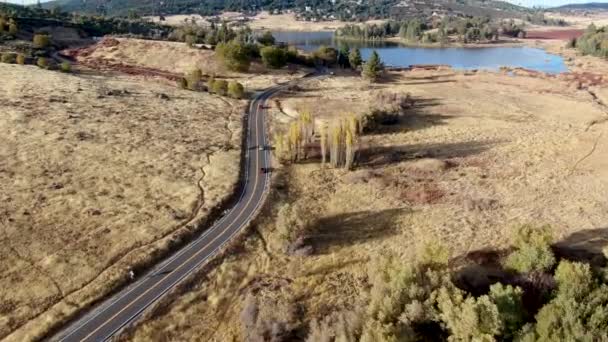 Vista aérea de pequeña carretera con coche al lado del lago Cuyamaca, California, EE.UU. — Vídeo de stock