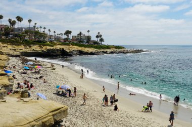 Sahile gidenler La Jolla Koyu 'nda güneşli bir günün tadını çıkarıyorlar.