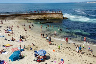 Sahile gidenler La Jolla Koyu 'nda güneşli bir günün tadını çıkarıyorlar.