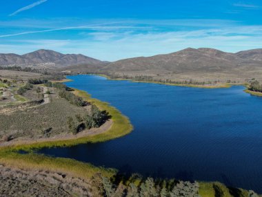 Mavi gökyüzü ve dağlı Otay Gölü rezervuarının havadan görünüşü