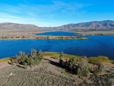 Mavi gökyüzü ve dağlı Otay Gölü rezervuarının havadan görünüşü