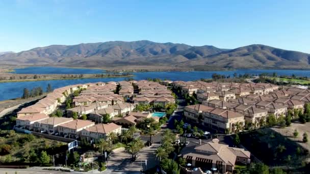 Вид с воздуха на идентичную резиденциальную квартиру с большим озером и горой на заднем плане — стоковое видео