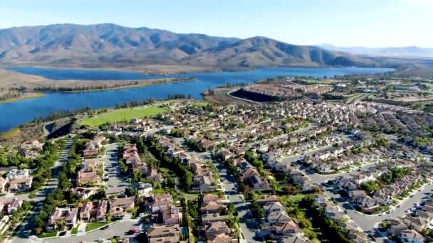 Vista aerea di identica casa suddivisione residenziale con grande lago e montagna sullo sfondo — Video Stock