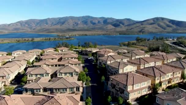 Vista aérea de condominio residencial idéntico con gran lago y montaña en el fondo — Vídeos de Stock