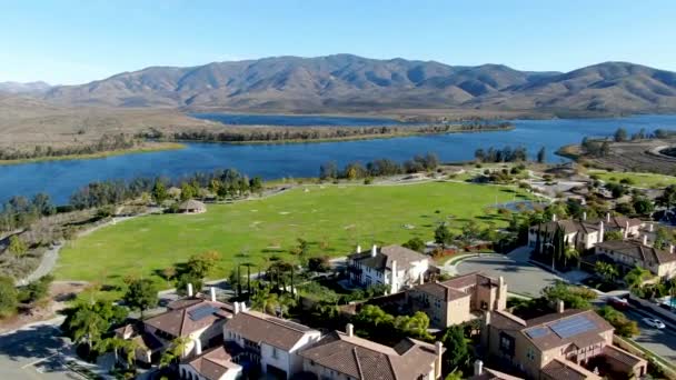 Luchtfoto van identieke residentialcondo met groot meer en berg op de achtergrond — Stockvideo