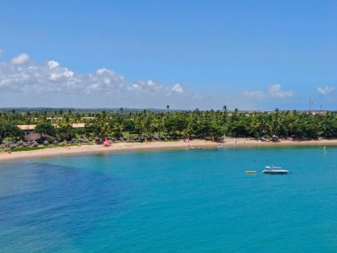 Praia 'daki tropikal beyaz kumsal, palmiye ağaçları ve turkuaz berrak deniz sularının havadan görünüşü