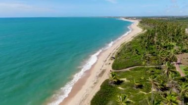 Aerial view of tropical white sand beach and turquoise clear sea water with small waves.
