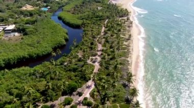 Aerial view of tropical white sand beach and turquoise clear sea water with small waves.