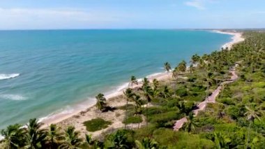 Aerial view of tropical white sand beach and turquoise clear sea water with small waves.