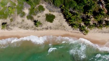 Aerial view of tropical white sand beach and turquoise clear sea water with small waves.