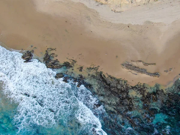 Вид згори на океанські хвилі, що миють узбережжя Тихого океану. — стокове фото