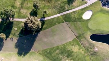 Aerial top view of golf course with green field and sand bunkers