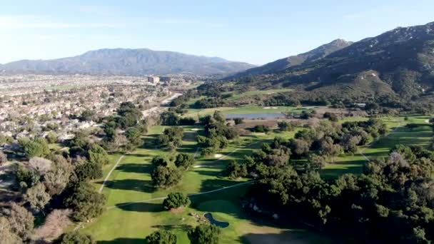 Letecký pohled na golfové hřiště se zeleným polem v údolí. — Stock video
