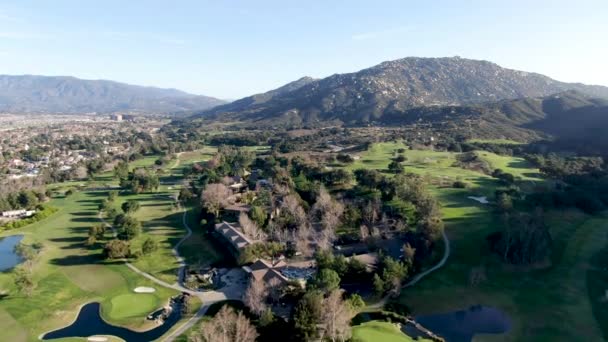 Luchtfoto van golfbaan met groen veld in de vallei. — Stockvideo