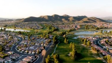 Gün batımında şehir evleri ve lüks villalarla çevrili golf sahasının havadan görünüşü, Temecula