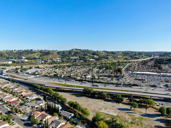Aerial view of highway with traffic surrounded by houses in Diamond Bar City. Intersection city transport road with vehicle movement. Eastern Los Angeles, California, USA.