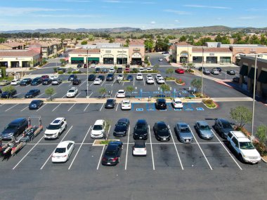 Süpermarketi, restoranı ve araba için park yeri olan küçük kasaba alışveriş merkezinin hava manzarası..
