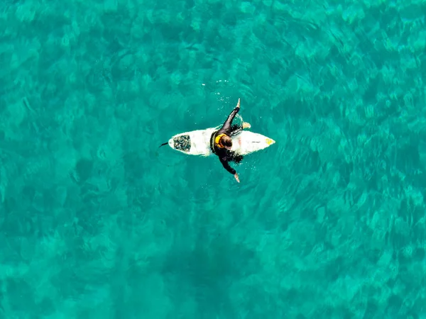 Vista aérea de surfistas esperando, remando e desfrutando de ondas em uma bela água azul — Fotografia de Stock